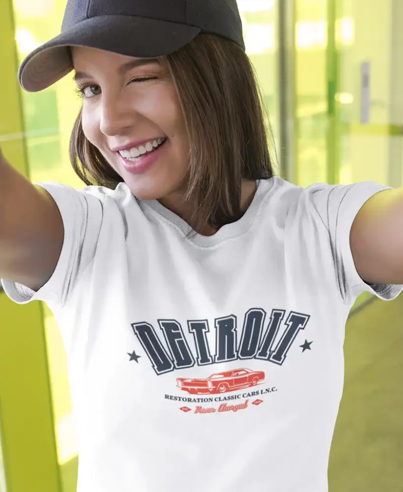 chica en camiseta color blanco con diseño detroit , de marca rebels and engines