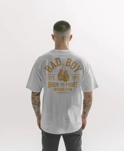 Home chico modelo en camiseta blanco oversize con diseno de color vintage dorado bad boy vista frontal