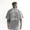 chico modelo en camiseta gris claro oversize con diseno de color blanco, bad boy, edicion limitada, vista trasera