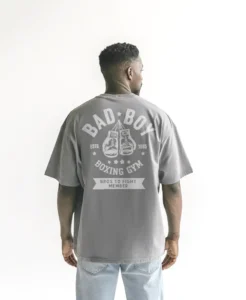 Marcas de la tienda Ditesia.com chico modelo en camiseta gris claro oversize con diseno de color blanco, bad boy, edicion limitada, vista trasera