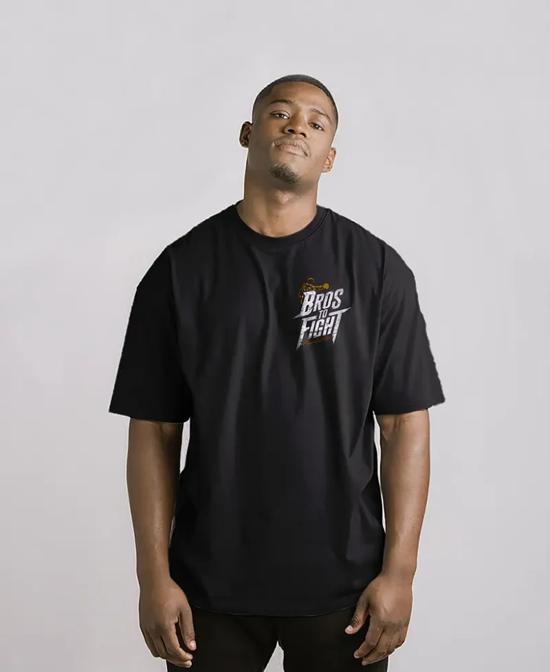 chico modelo en una camiseta negra oversize con logo y una imagen de un boxeador