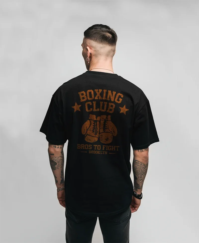 modelo en camiseta negra con diseño bros to fight box club de colo rojo , vista trasera
