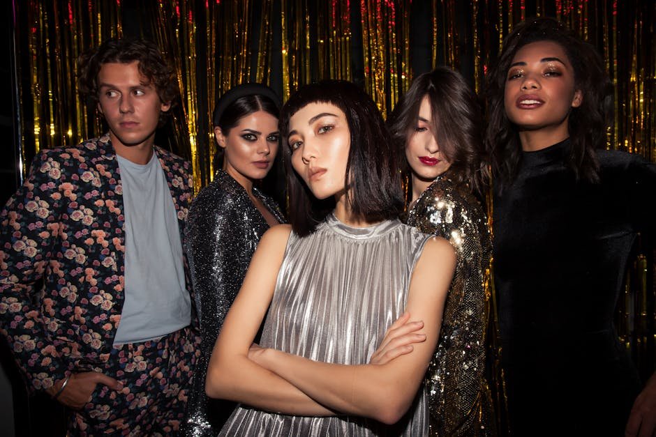 Chic group of young adults posing in glamorous attire, ready for a fashionable night out.